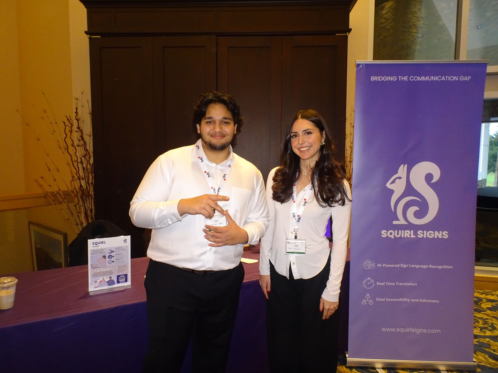 Shehriyar Nasri and Fiona Hanasavha at the Squirl Signs booth, beside a banner reading Bridging the communication gap